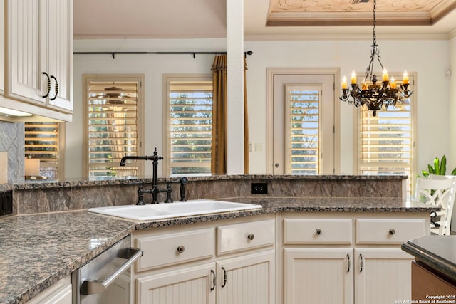 kitchen featuring ornamental molding, a tray ceiling, dishwasher, and sink