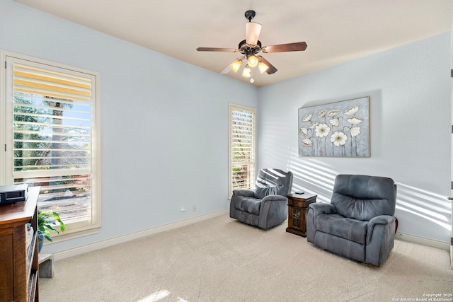 living area with ceiling fan and light colored carpet