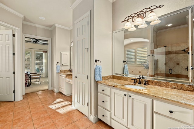 bathroom featuring vanity, crown molding, a shower with shower door, and tile patterned floors