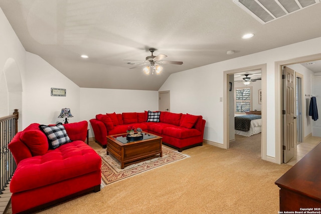 carpeted living room with ceiling fan and lofted ceiling