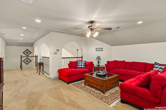 carpeted living room with ceiling fan, lofted ceiling, and a textured ceiling