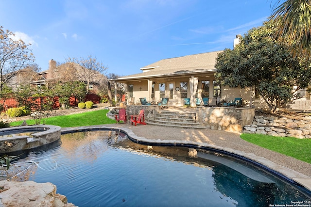 rear view of house featuring a pool with hot tub, an outdoor bar, and a patio area