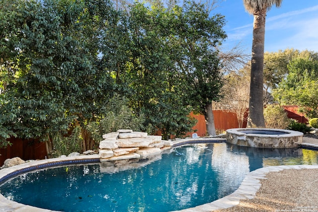 view of swimming pool with an in ground hot tub