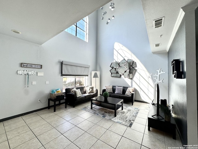 tiled living room featuring a towering ceiling, ornamental molding, and a textured ceiling