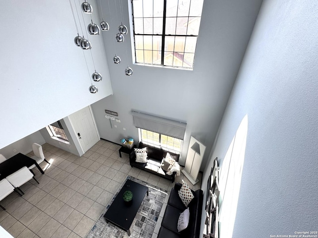 living room featuring light tile patterned flooring and a high ceiling