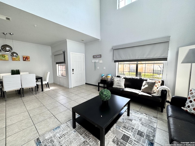 tiled living room with crown molding and a towering ceiling