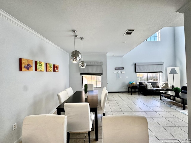 dining area featuring crown molding, a healthy amount of sunlight, and light tile patterned floors