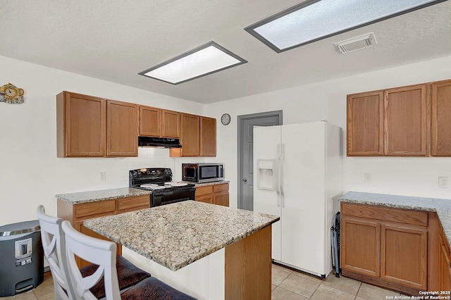 kitchen featuring a breakfast bar, a center island, light stone counters, white fridge with ice dispenser, and black range with electric cooktop