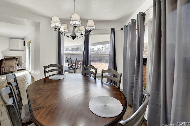 tiled dining space with a textured ceiling and a notable chandelier