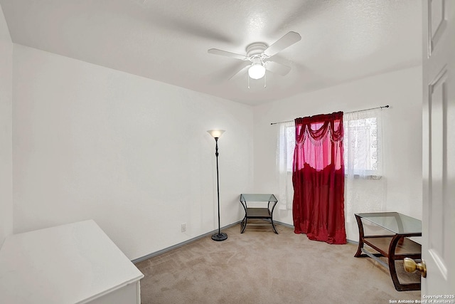 interior space featuring light colored carpet and ceiling fan