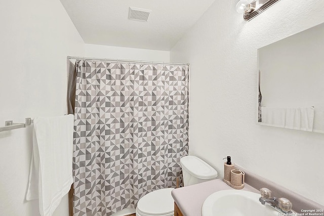 bathroom with walk in shower, vanity, and toilet