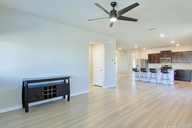 living room featuring ceiling fan and light wood-type flooring