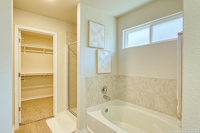 bathroom featuring shower with separate bathtub and hardwood / wood-style floors