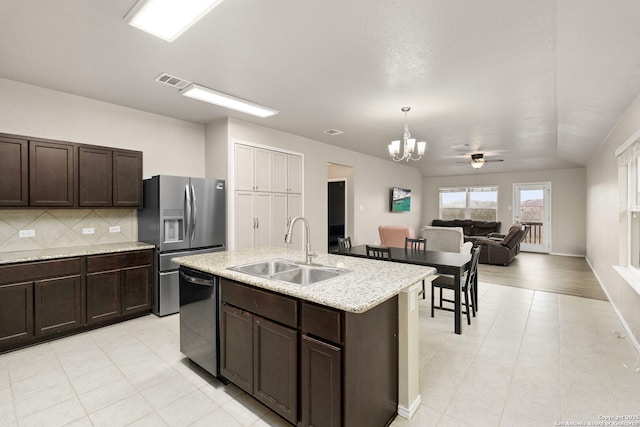 kitchen featuring sink, a center island with sink, stainless steel fridge, dishwashing machine, and decorative backsplash