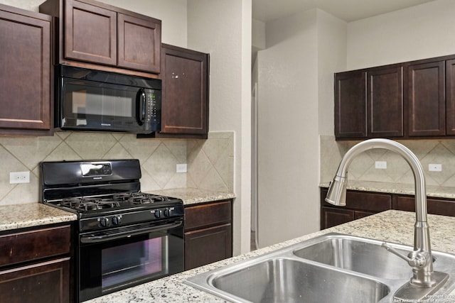 kitchen featuring sink, tasteful backsplash, dark brown cabinetry, black appliances, and light stone countertops