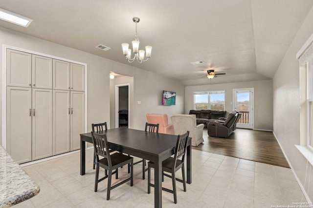 dining area featuring ceiling fan with notable chandelier