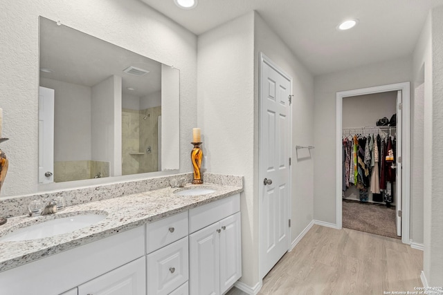 bathroom featuring walk in shower, vanity, and hardwood / wood-style floors