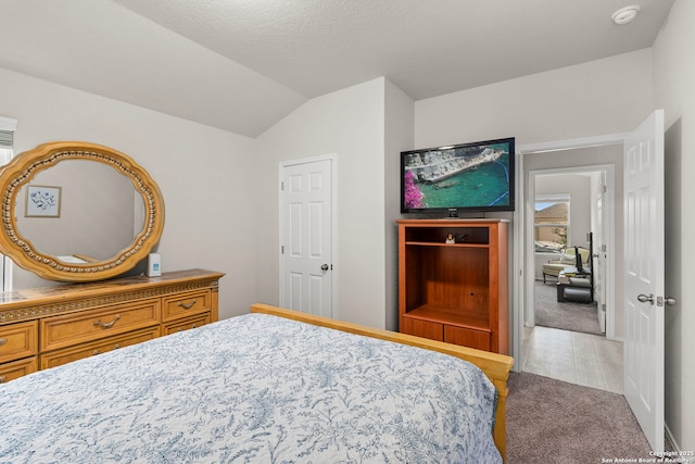 carpeted bedroom with lofted ceiling