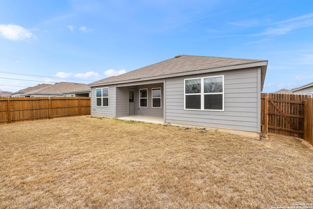 back of property with a lawn and a patio