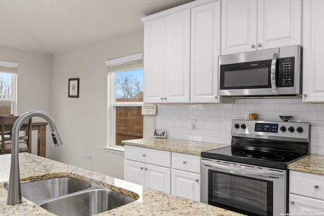 kitchen with tasteful backsplash, white cabinetry, appliances with stainless steel finishes, and sink