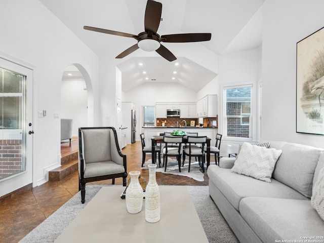 tiled living room featuring high vaulted ceiling and ceiling fan