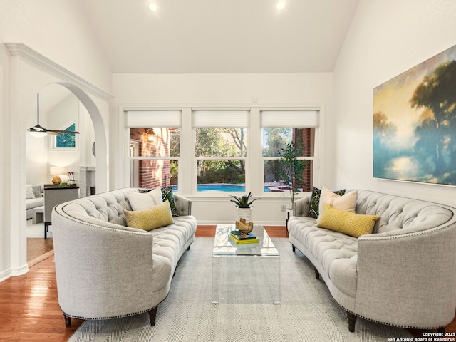 living room featuring vaulted ceiling, wood-type flooring, and ceiling fan