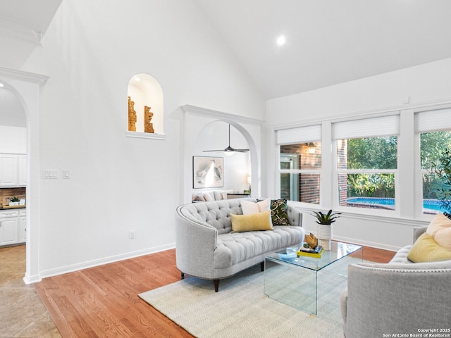 living room featuring high vaulted ceiling and light wood-type flooring