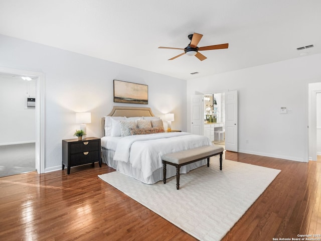 bedroom featuring dark wood-type flooring, connected bathroom, and ceiling fan