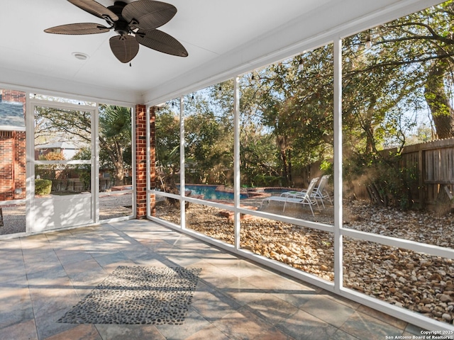 unfurnished sunroom featuring ceiling fan