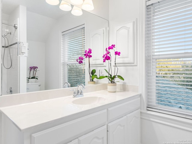 bathroom featuring vanity, a tile shower, and a wealth of natural light