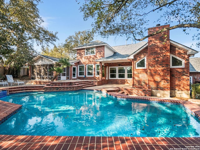 view of pool featuring a patio area and a sunroom