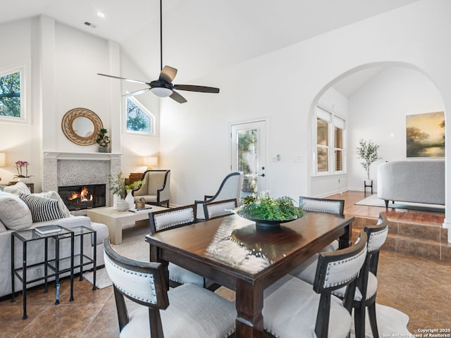 dining area with ceiling fan, a healthy amount of sunlight, and high vaulted ceiling