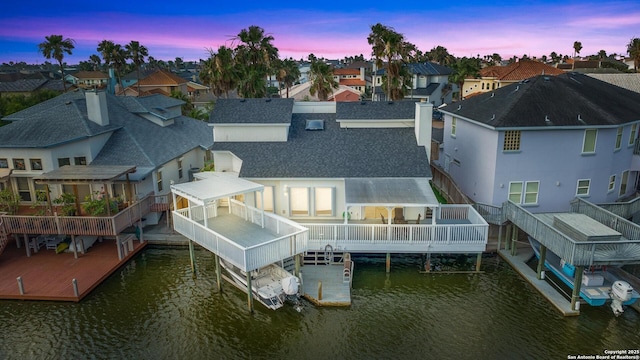 back house at dusk featuring a water view