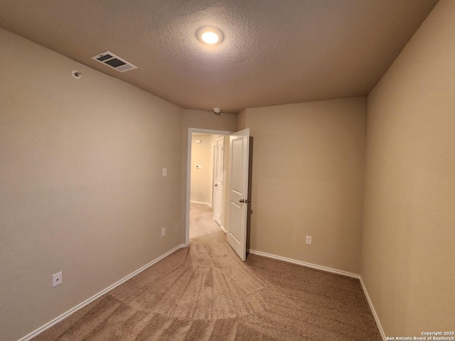 spare room with a textured ceiling and carpet