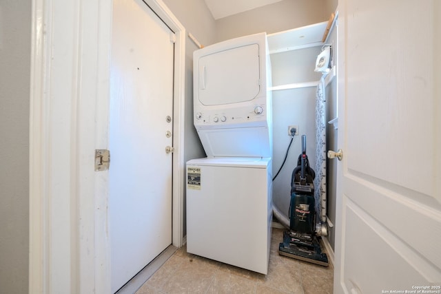 laundry room featuring light tile patterned floors and stacked washer / dryer