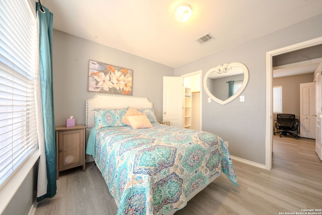 bedroom featuring multiple windows and light wood-type flooring