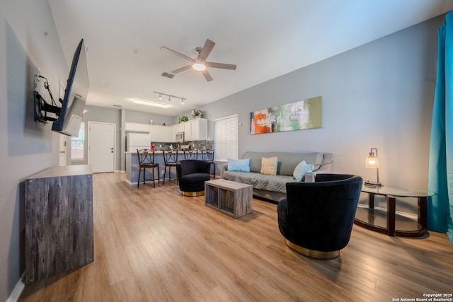 living room with light hardwood / wood-style flooring and ceiling fan