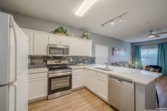 kitchen featuring white cabinetry, sink, stainless steel appliances, and kitchen peninsula