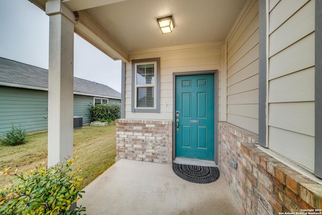 entrance to property featuring a yard and central air condition unit