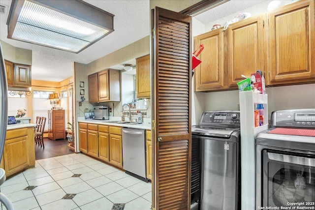 kitchen featuring separate washer and dryer, sink, stainless steel dishwasher, and a textured ceiling