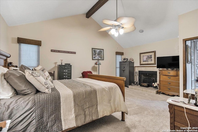 bedroom featuring lofted ceiling with beams, a tile fireplace, light colored carpet, and ceiling fan