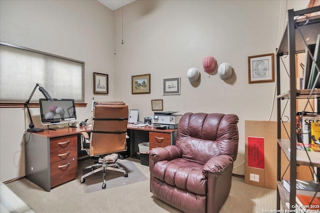 office area featuring a high ceiling and light carpet