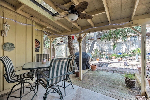 wooden deck featuring grilling area and ceiling fan