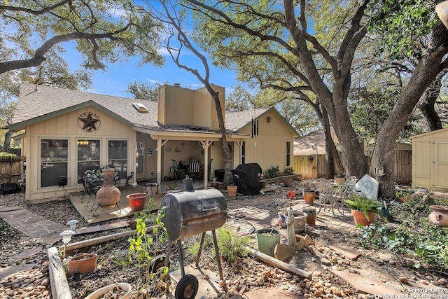 rear view of house with a shed and a patio