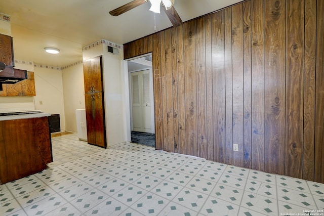 kitchen with wooden walls and ceiling fan