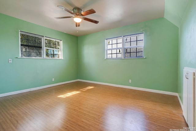 empty room featuring light hardwood / wood-style flooring, ceiling fan, and vaulted ceiling