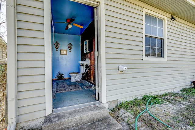 view of exterior entry with ceiling fan