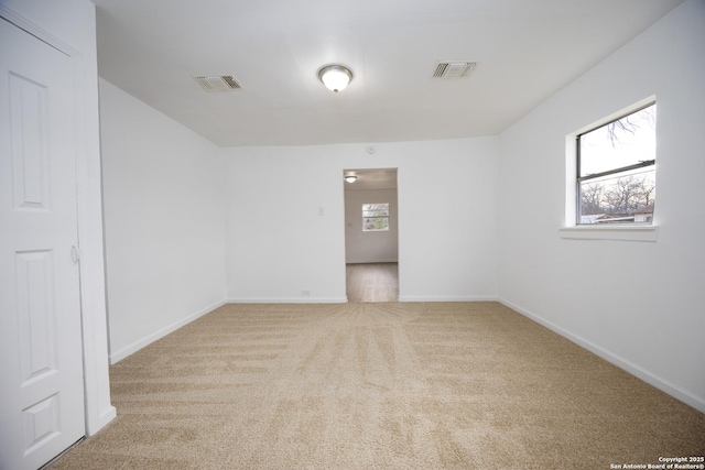 carpeted spare room featuring a healthy amount of sunlight