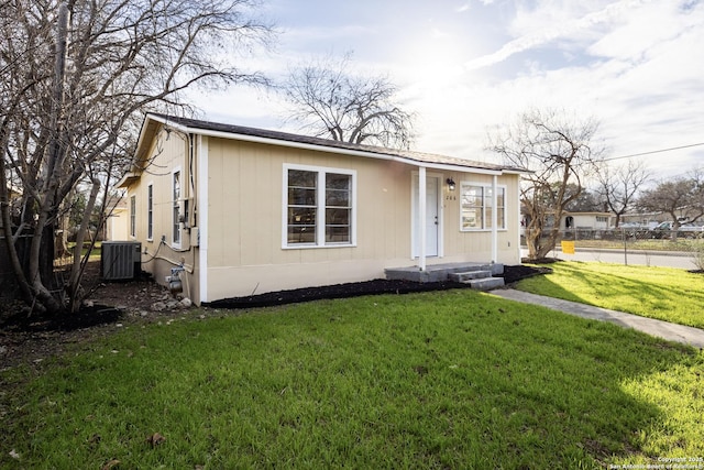 view of front of property featuring a front yard and cooling unit