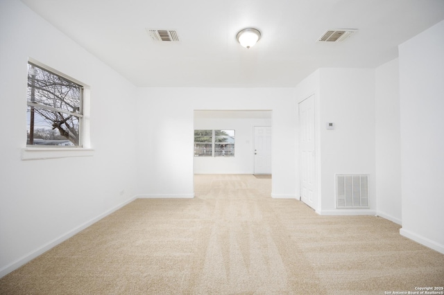 unfurnished room with a wealth of natural light and light colored carpet